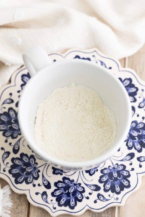 A mug with flour, sugar, and baking powder.