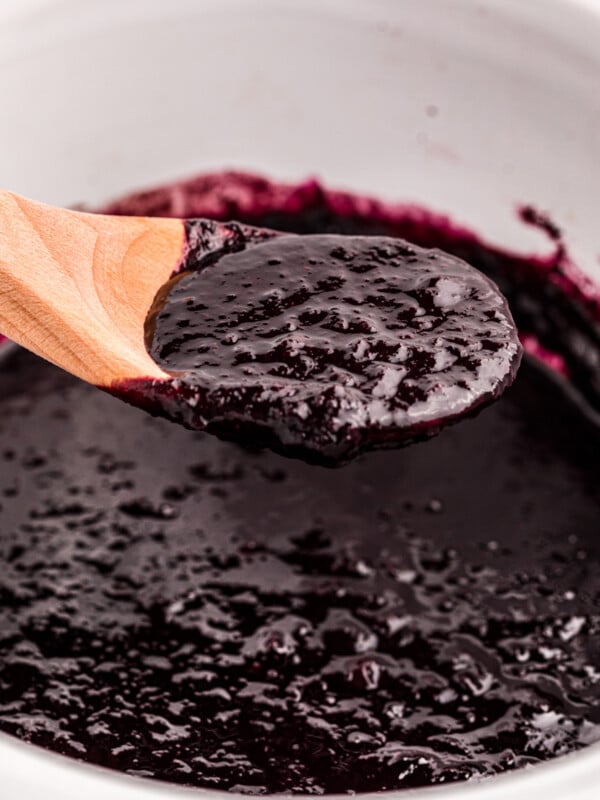 Blueberry butter on a spoon coming from a slow cooker.