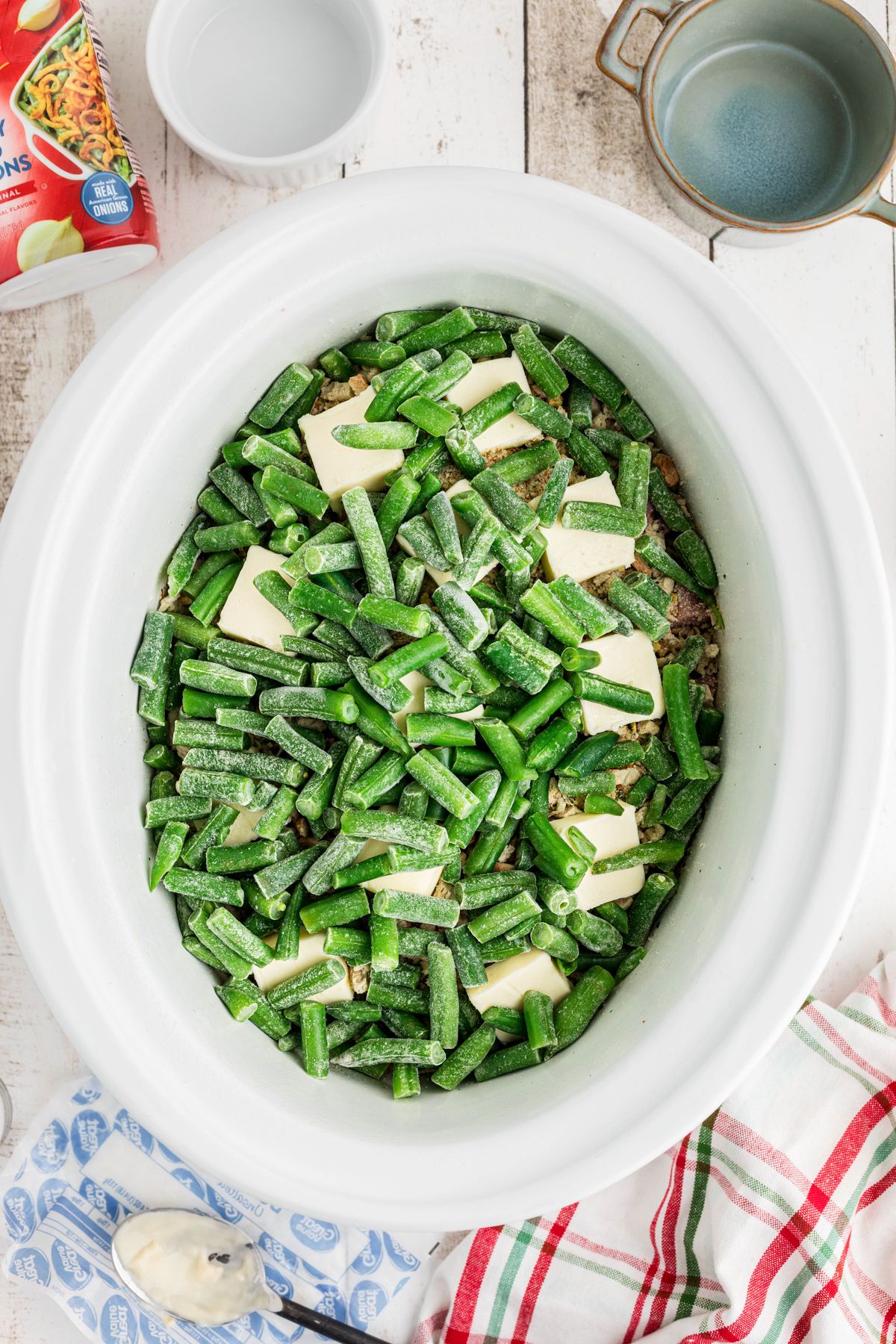 Green beans added to a crockpot.