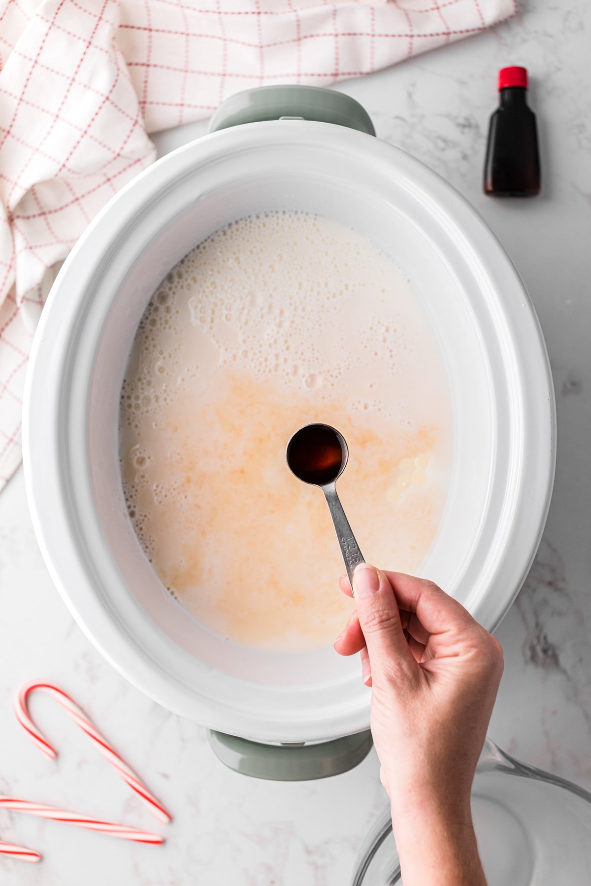 Adding vanilla extract to a crockpot.