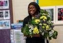 Member of staff at SHINE Merton with donated flowers