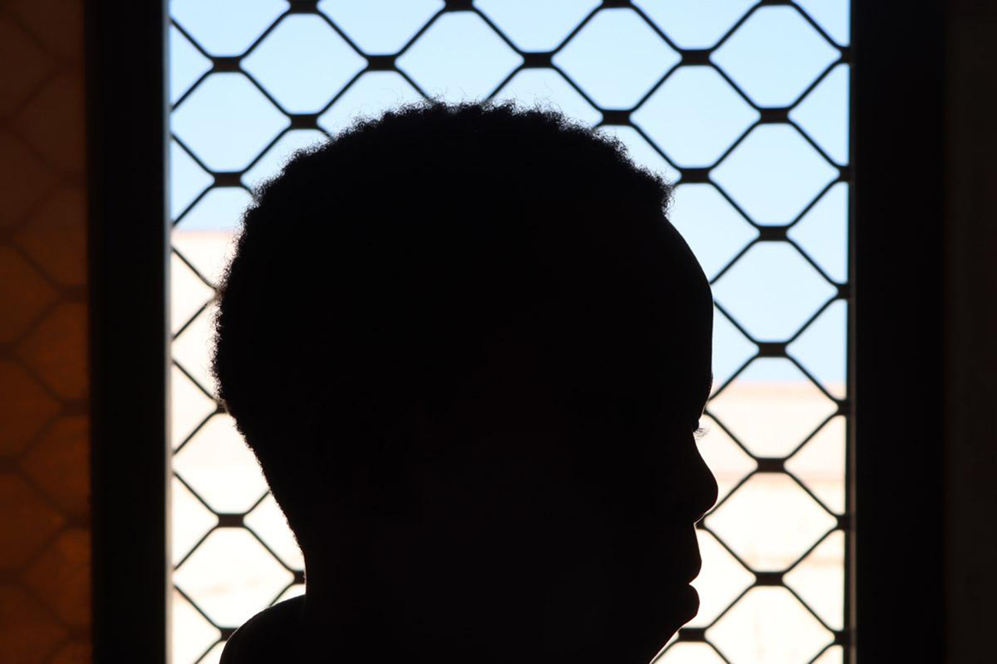 Close-up of an Ethiopian woman's face in shadow with a window in the background.