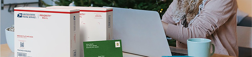 A woman preparing to ship holiday gifts with a Priority Mail Express box and a Priority Mail box.